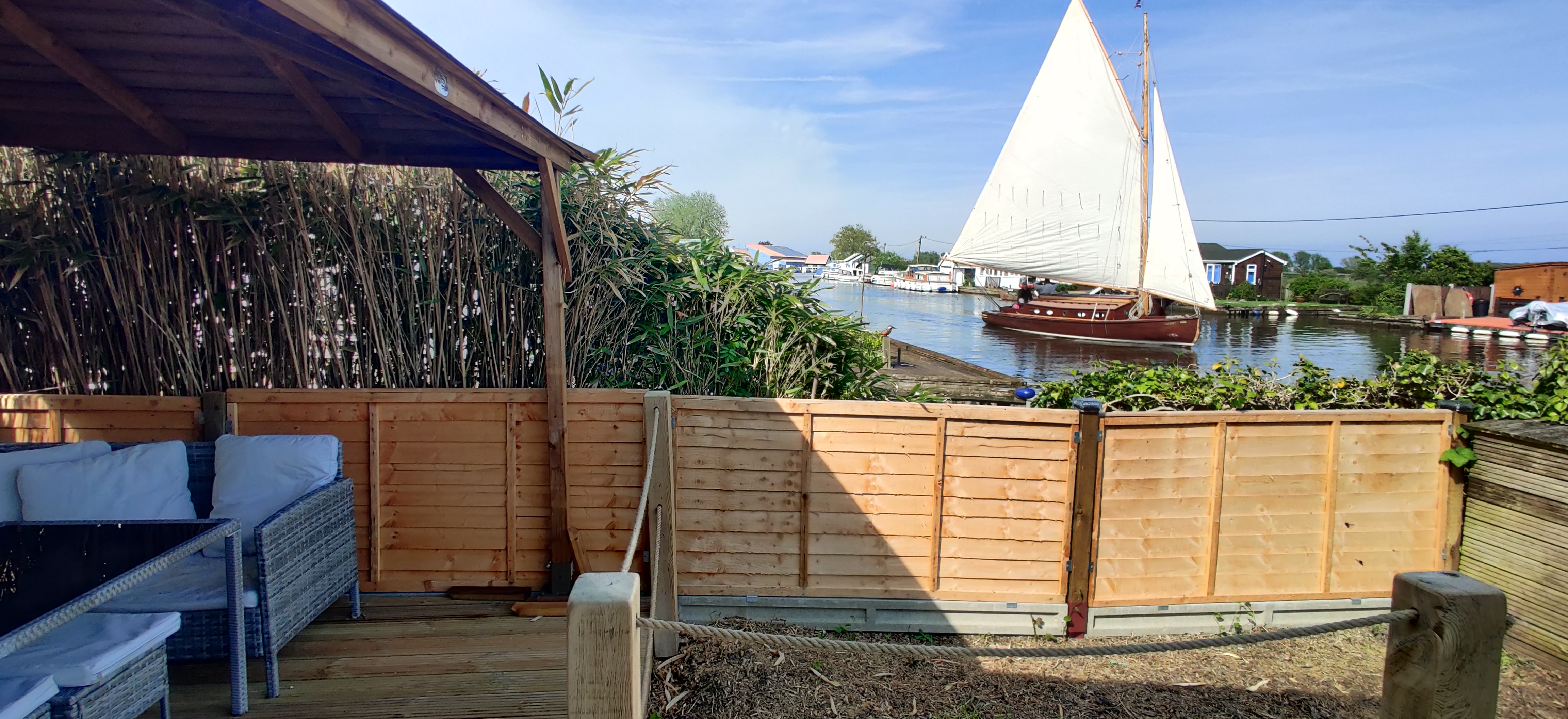 A traditional woden boat sailing past Windy Ridge Waterfront Cottage